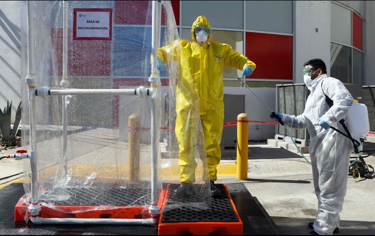Trabajadores de la salud demuestran el proceso de sanitización en el recién inaugurado hospital móvil para pacientes de COVID-19 en Ciudad Juárez. AP/H. Martínez