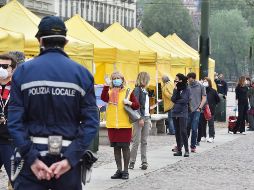 Un policía vigila este domingo mientras personas acuden a un mercado abierto en Turín, Italia. EFE/A. Di Marco