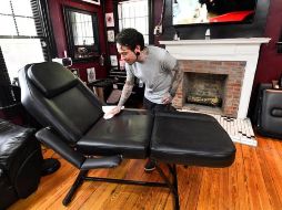 Un tatuador desinfecta su mobiliario en Atlanta, Georgia, tras recibir autorización para abrir este viernes. EFE/J. Amis