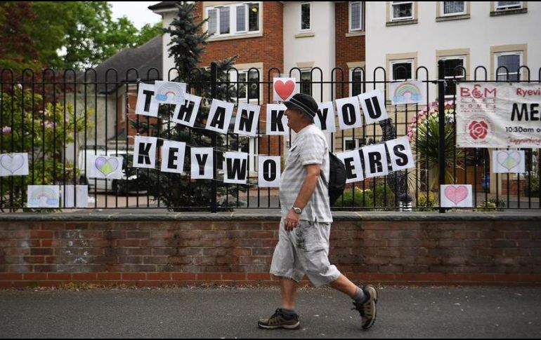 Un hombre camina en medio de un anuncio de agradecimiento a personal de salud. EFE/A. Rain