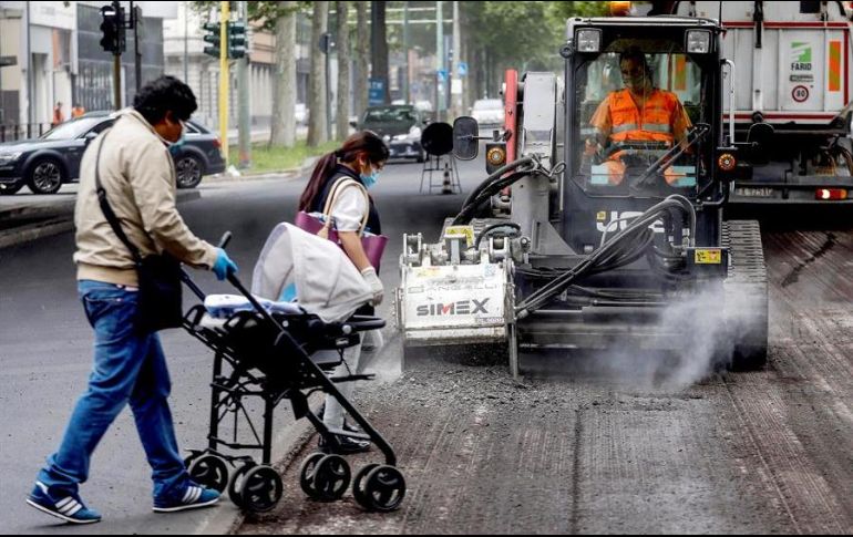 Trabajadores de la construcción realizan sus labores en la calle Certosa, en Milán. EFE/M. Balti