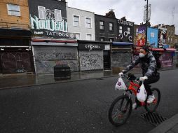Una persona a bordo de una bicicleta carga comida para entregar a domicilio, en un barrio de Inglaterra. EFE/A. Rain