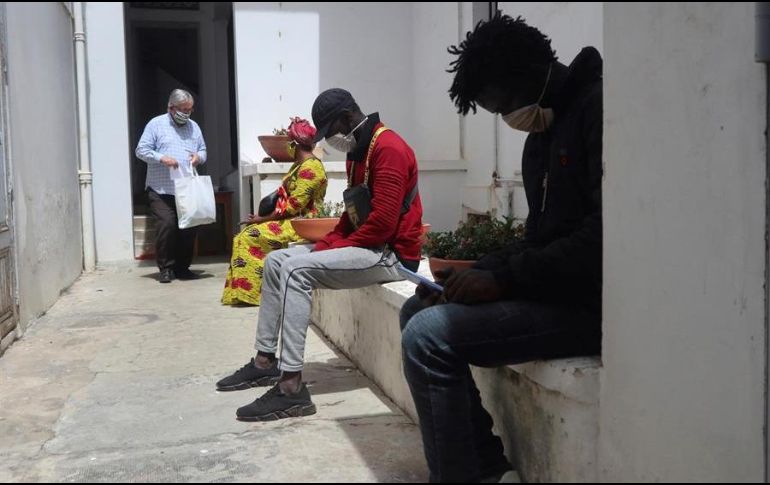 El sacerdote Daniel Nourissat (i) reparte lotes de alimentos en la Catedral de Rabat a inmigrantes subsaharianos que han caído en la precariedad en Marruecos por causa del COVID-19. EFE/J. Otazu