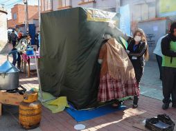 Una mujer aimara ingresa una cámara de medicina tradicional, donde usan plantas de eucalipto, manzanilla y huira huira para tratar enfermedades respiratorias, en El Alto. EFE/M. Alipaz