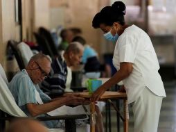Magaly Lorenzo (d) le da el desayuno a Ascanio González, de 76 años, en el asilo Hogar Bolívar en la Ciudad de Panamá. EFE/ B. Velasco