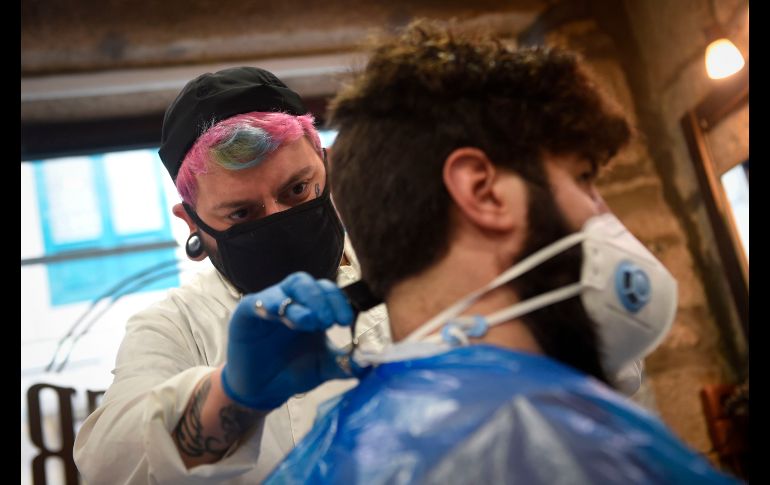 David Cores corta el pelo de su primer cliente tras reabrir hoy en Pontevedra, España. AFP/M. Riopa