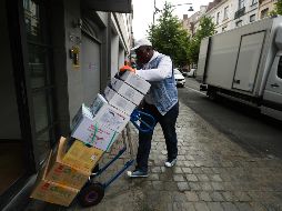 Portero entrega productos en un edificio de Bruselas. XINHUA/Z. Huansong