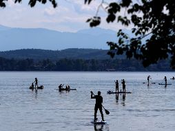 Personas acuden este domingo al lago Starnberger, frente a la montaña más alta de Alemania, Zugspitze, cerca de la ciudad de Seeshaupt. AP/M. Schrader
