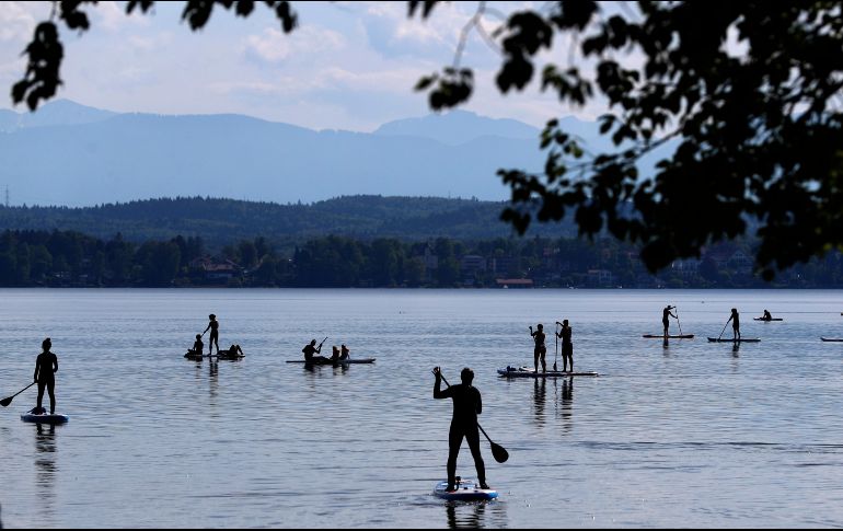Personas acuden este domingo al lago Starnberger, frente a la montaña más alta de Alemania, Zugspitze, cerca de la ciudad de Seeshaupt. AP/M. Schrader