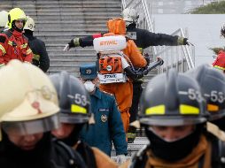 Bomberos son desinfectados después de apagar el fuego en el hospital acondicionado para tratar a pacientes de COVID-19. EFE/A. Maltsev