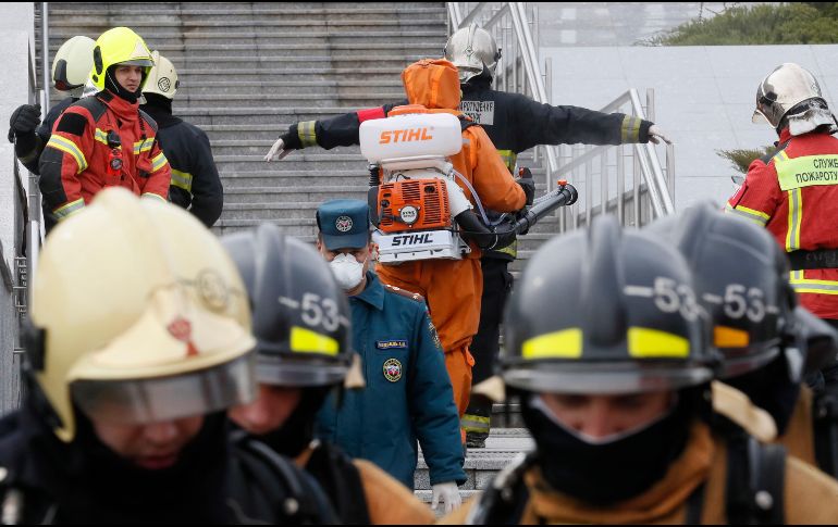 Bomberos son desinfectados después de apagar el fuego en el hospital acondicionado para tratar a pacientes de COVID-19. EFE/A. Maltsev