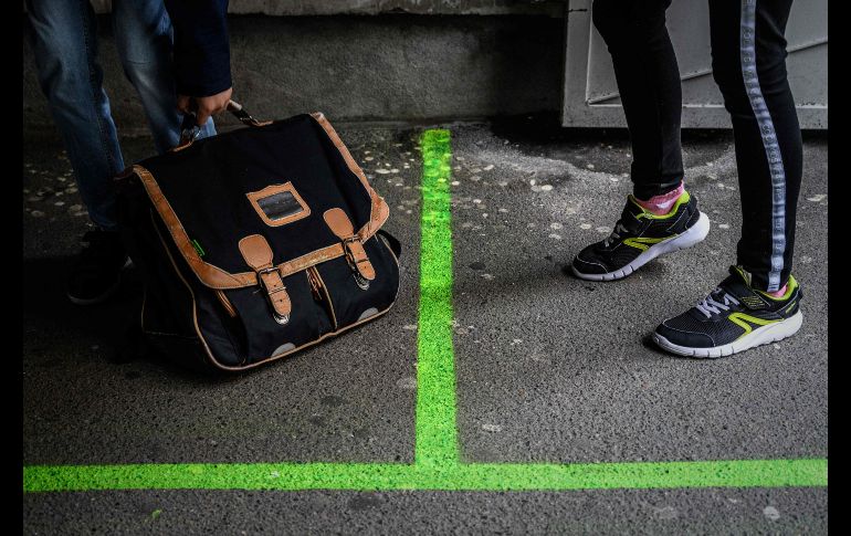 Estudiantes se paran entre marcas de distanciamiento social en una escuela en París. AFP/P. Lopez