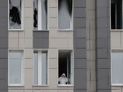 Un médico se asoma desde una ventana del sexto piso del hospital San Jorge, donde ayer inició un incendio. EFE/A. Maltsev