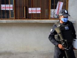 Un agente de la Policía estatal resguarda una tienda clausurada donde se vendía alcohol adulterado en el municipio de Jonacatepec, Morelos. EFE/T. Rivera