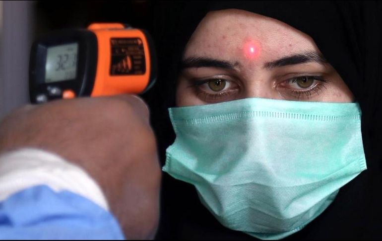 Un trabajador de una estación de tren mide la temperatura de una pasajera en Karachi, Pakistán, este miércoles. EFE/R. Khan