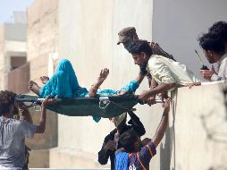 Voluntarios trasladan a uno de los heridos por la colisión de la aeronave en Karachi. AP/F. Khan