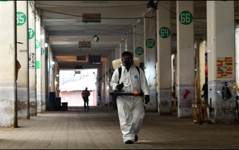 Un equipo de sanidad desinfecta este sábado locales en el mercado de Jamaica, en la Ciudad de México. EFE/J. Núñez