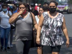 Mujeres caminan por un mercado mientras utilizan tapabocas como medida de prevención ante el COVID-19, en Managua. EFE/J. Torres