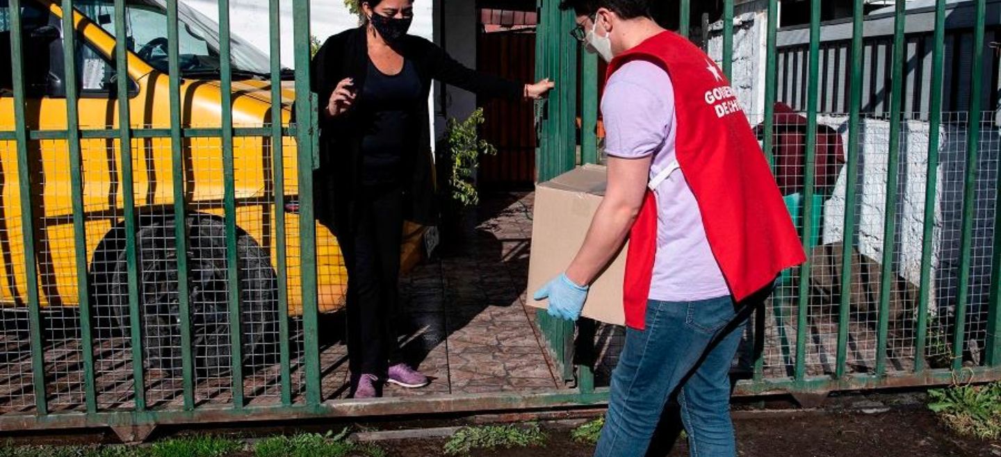 Escoltados por el Ejército, trabajadores municipales en La Pintana han repartido dos mil cajas de las 40 mil previstas. EFE/M. Bernetti