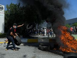 Cientos de trabajadores se concentran este jueves ante la planta y han empezado a quemar neumáticos como protesta por la decisión de la compañía automotriz. AFP/Ll. Gene