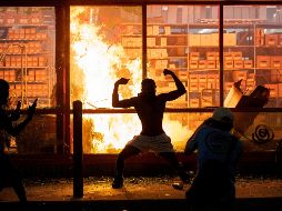 Un manifestante posa frente a una tienda incendiada. AP/ Star Tribune/C. Gonzalez
