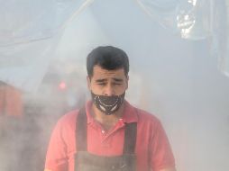 Vendedor pasa por el túnel sanitizador en el ingreso al mercado de Abastos. EL INFORMADOR/F. Atilano