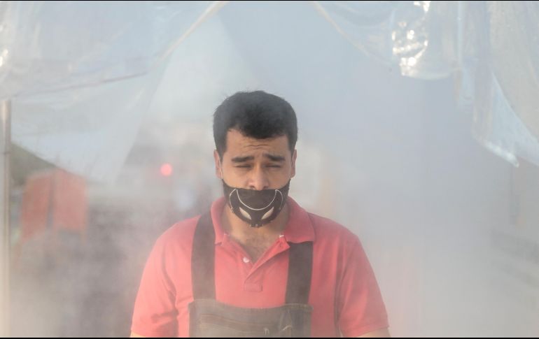 Vendedor pasa por el túnel sanitizador en el ingreso al mercado de Abastos. EL INFORMADOR/F. Atilano