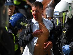 Policías trasladaron a un hombre herido tras los enfrentamientos de ayer en la plaza Trafalgar de Londres. AFP/D. Leal-Olivas