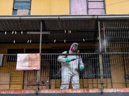 Un trabajador desinfecta viviendas en Santiago. Conjuntos de edificios altos con varios apartamentos por piso se han convertido en foco de contagio. AFP/ARCHIVO