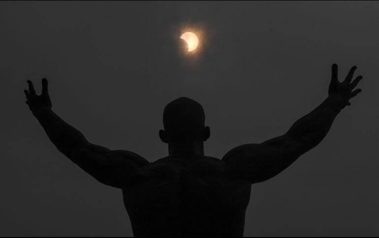 Un hombre recibe con los brazos abiertos al eclipse solar parcial desde Changchun, provicncia de Jilin, en China. Xinhua / Z. Nan