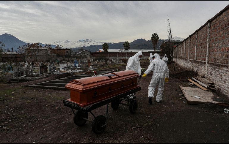 Trabajadores dirigen un ataúd en el cementerio Católico en Santiago, Chile. AP/E. Félix