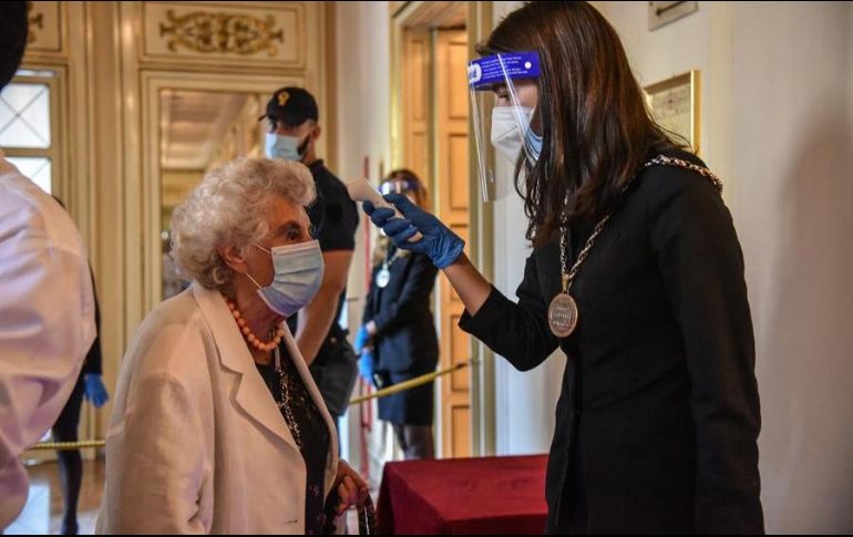 Una empleada del Teatro alla Scala, en Milán, mide la temperatura de una asistente a uno de los espectáculos. EFE/M. Corner