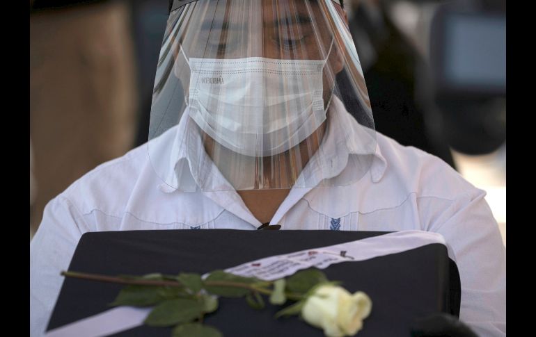 Una persona carga la urna con los restos de un familiar. AP/F. Llano