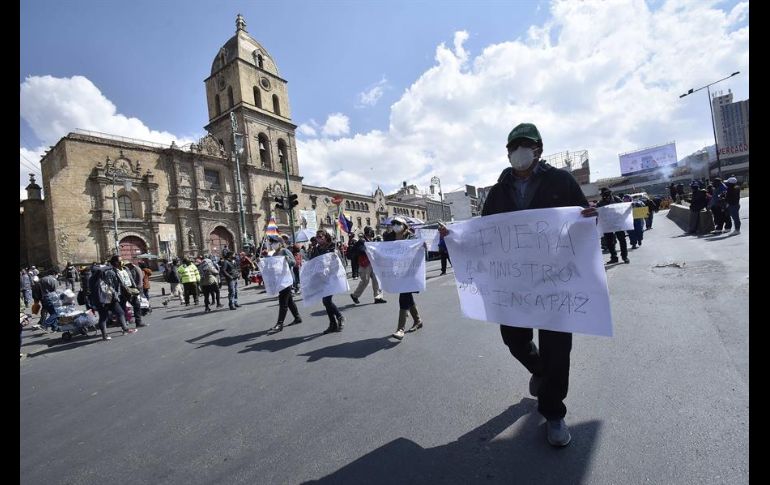 Docentes y organizaciones obreras muestran pancartas y ondean banderas este martes durante una protesta en La Paz. EFE