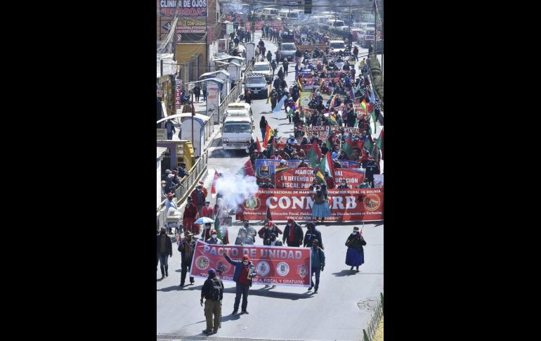 Docentes y organizaciones obreras muestran pancartas y ondean banderas este martes durante una protesta en La Paz. EFE