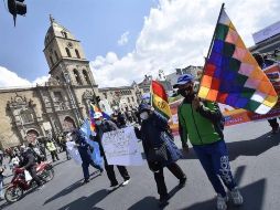 Docentes y organizaciones obreras muestran pancartas y ondean banderas este martes durante una protesta en La Paz. EFE