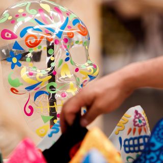 Fabrican cubrebocas y caretas inspirados en Día de Muertos
