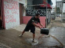 Un trabajador mecánico saca el agua de su local. La inundación agua alcanzó 1.5 metros. EL INFORMADOR/F. Atilano