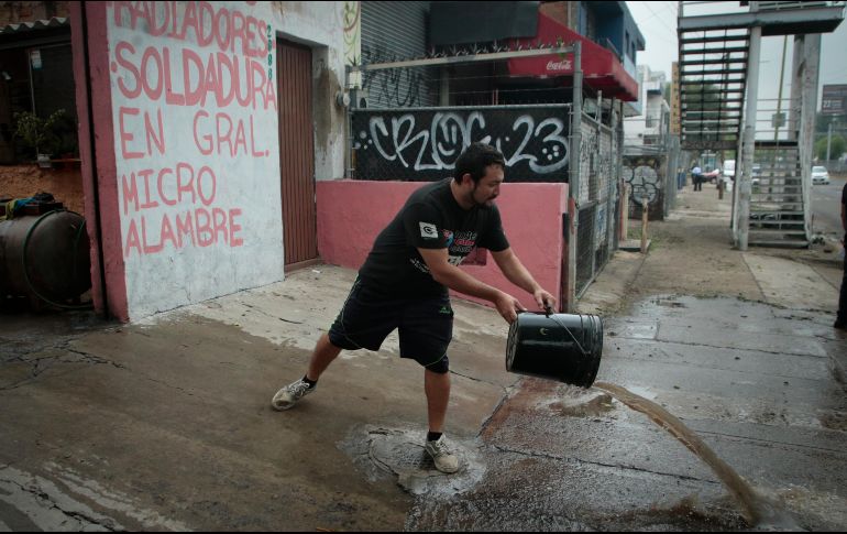 Un trabajador mecánico saca el agua de su local. La inundación agua alcanzó 1.5 metros. EL INFORMADOR/F. Atilano
