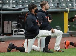 Jaylin Davis (izquierda), se arrodilló durante el himno y recibió el apoyo de su equipo. AP