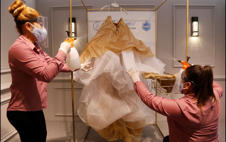 Trabajadoras de la tienda Ragazza desinfectan un vestido de novia. EFE/F. Guasco