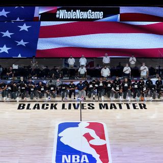 Jugadores se arrodillan durante el himno en el regreso de la NBA