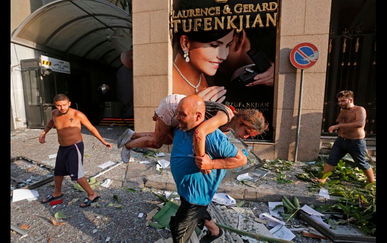 Un hombre traslada a una herida en el barrio de Achrafiyeh, en el centro de Líbano. AFP/M. Tahtah