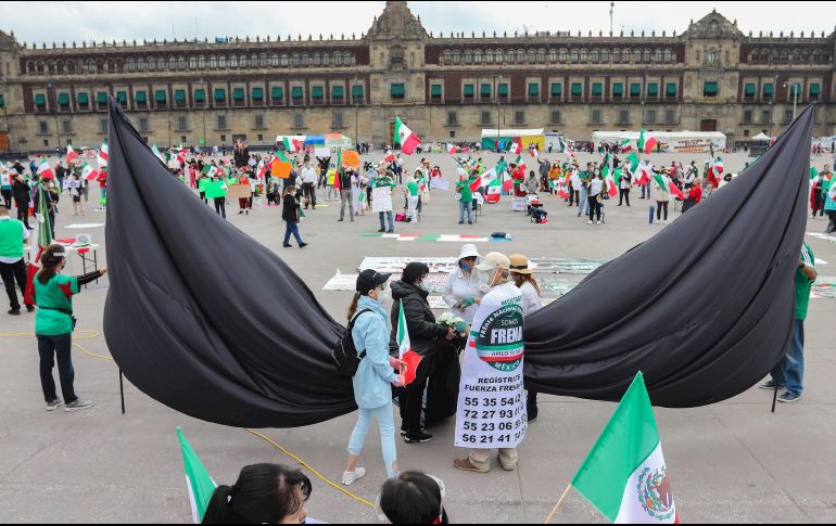 Manifestantes colocan un crespón en conmemoración por las víctimas de la violencia y fallecidos por el COVID-19 durante la protesta  en el Zócalo. EFE/J. Pazos
