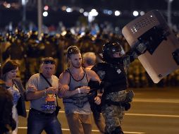 Policías antimotines detienen a manifestantes en Minsk. AFP/S. Gapon