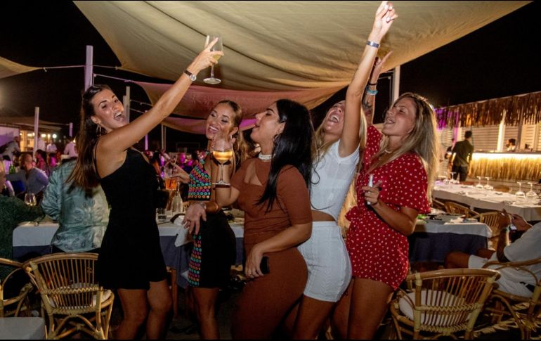 Mujeres bailan en un restaurante al aire libre junto a la playa en Fregene, cerca de Roma. El gobierno teme que la vida nocturna contribuya a aumentar los contagios. AFP/T. Fabi
