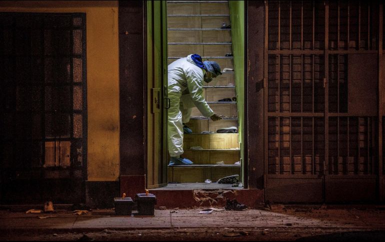 Un perito de la policía registra la salida de la discoteca en Lima. La estampido en el lugar provocó 13 muertes. EFE/ M. Flores