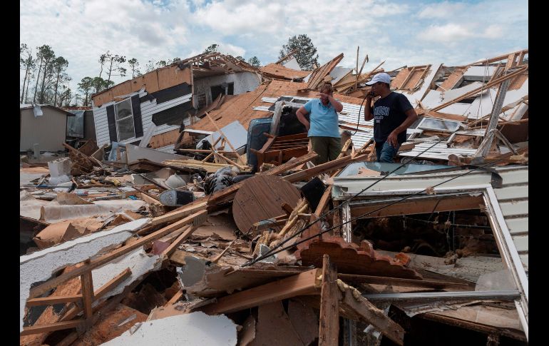 Una pareja camina entre los escombros de su casa rodante en la ciudad de Lake Charles, Luisiana, tras el paso del huracán 
