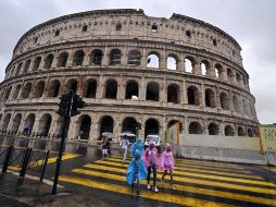 Varias personas caminan cerca del Coliseo romano durante un día lluvioso. El histórico edificio fue reabierto tras permanecer varios meses cerrado por la pandemia. EFE/R. Antimiani