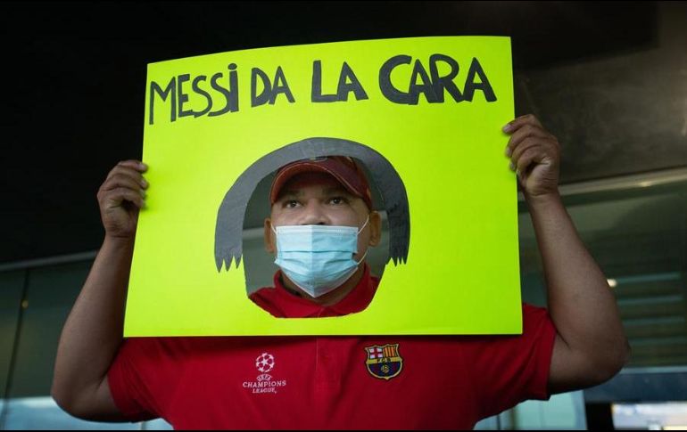 Un seguidor del FC Barcelona muestra una pancarta a Jorge Messi, padre y agente de Lionel Messi, a su llegada este miércoles a la terminal de vuelos privados del Aeropuerto de Barcelona. EFE/E. Fontcuberta
